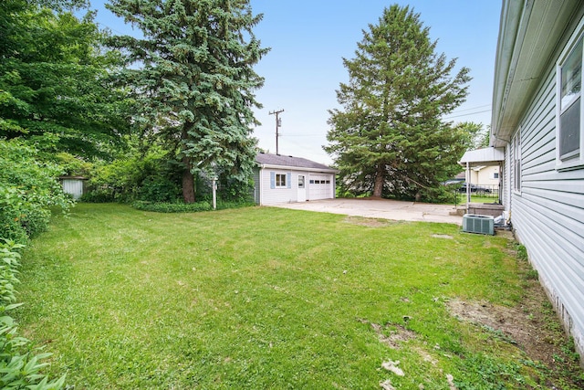 188 Redman Rd, Milan, MI 48160 - view of grassy yard with an outbuilding, a garage, cooling unit, and a patio area