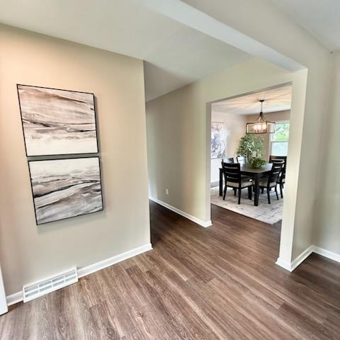 188 Redman Rd, Milan, MI 48160 - unfurnished room with wood finished floors, baseboards, and a chandelier