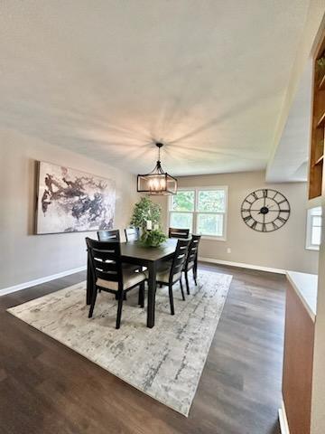 188 Redman Rd, Milan, MI 48160 - dining room featuring dark wood finished floors, baseboards, and a chandelier