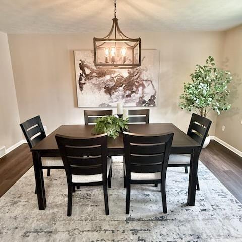 188 Redman Rd, Milan, MI 48160 - dining area featuring a chandelier, wood finished floors, and baseboards