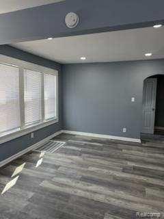 14557 Strathmoor St, Detroit, MI 48227 - empty room with baseboards, wood finished floors, recessed lighting, and arched walkways
