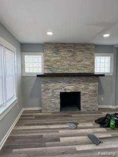 14557 Strathmoor St, Detroit, MI 48227 - unfurnished living room with baseboards, a stone fireplace, wood finished floors, and recessed lighting