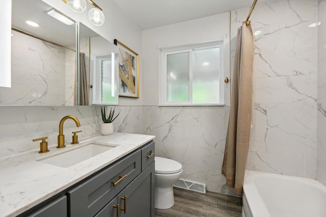 2419 Faye Dr, Ann Arbor, MI 48103 - full bath featuring vanity, toilet, wood finished floors, tile walls, and shower / bath combination with curtain