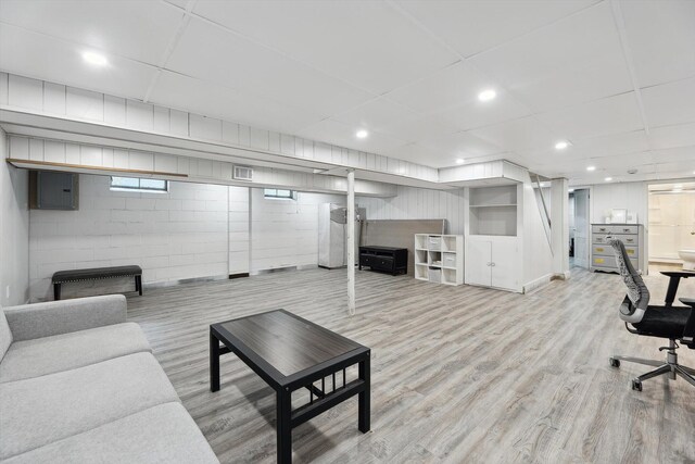 2419 Faye Dr, Ann Arbor, MI 48103 - living room featuring wood finished floors, a paneled ceiling, electric panel, concrete block wall, and recessed lighting
