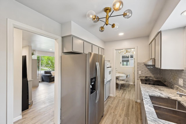 2419 Faye Dr, Ann Arbor, MI 48103 - kitchen featuring stainless steel fridge with ice dispenser, black electric stovetop, gray cabinetry, a chandelier, and under cabinet range hood