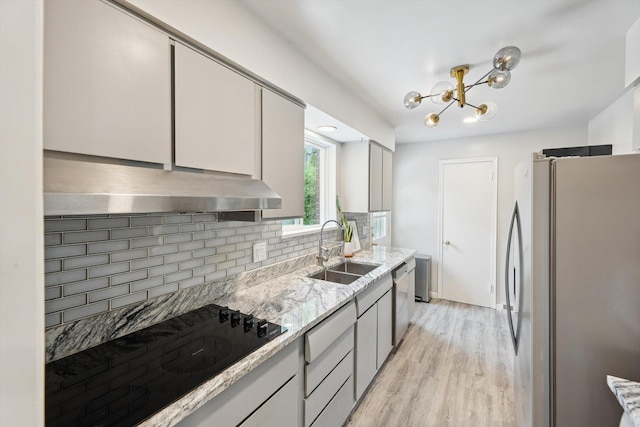 2419 Faye Dr, Ann Arbor, MI 48103 - kitchen with freestanding refrigerator, a sink, under cabinet range hood, backsplash, and black electric cooktop