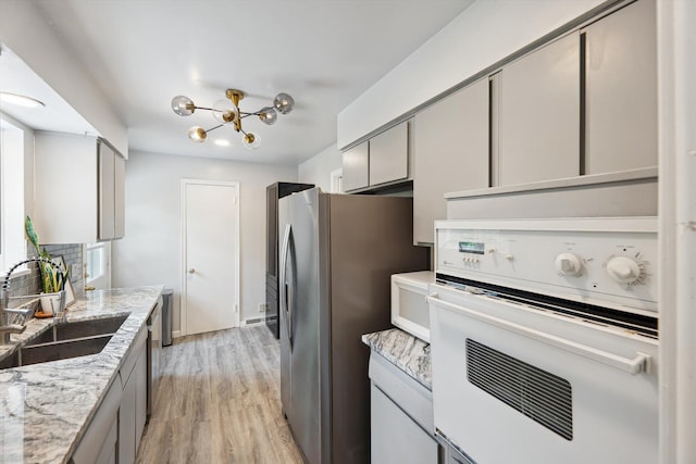 2419 Faye Dr, Ann Arbor, MI 48103 - kitchen featuring white appliances, a sink, gray cabinetry, a chandelier, and light wood-type flooring