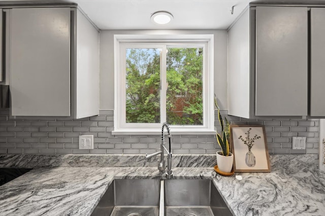 2419 Faye Dr, Ann Arbor, MI 48103 - kitchen featuring a sink, decorative backsplash, gray cabinets, and light stone countertops