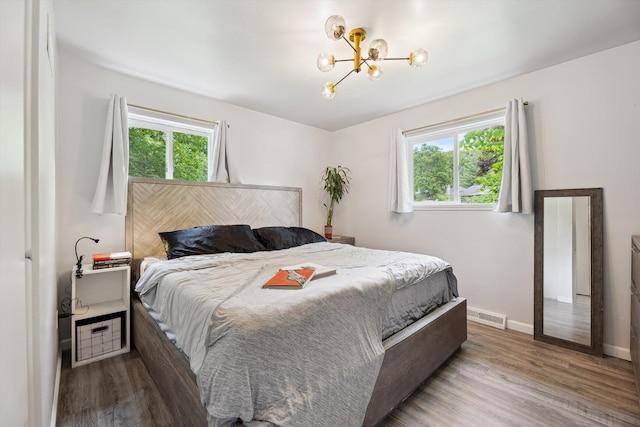 2419 Faye Dr, Ann Arbor, MI 48103 - bedroom with wood finished floors, a chandelier, and baseboards