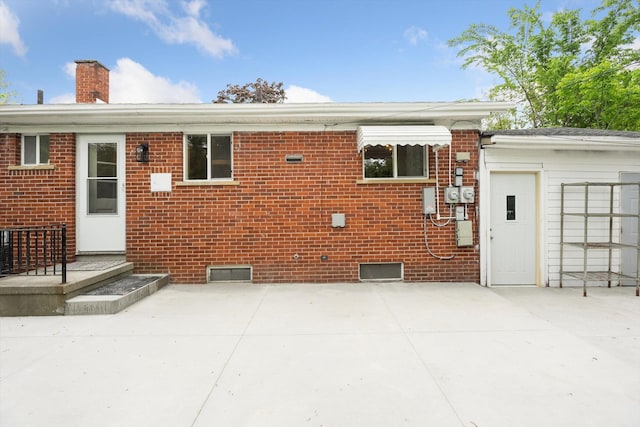 2419 Faye Dr, Ann Arbor, MI 48103 - back of house with brick siding, a chimney, and a patio area
