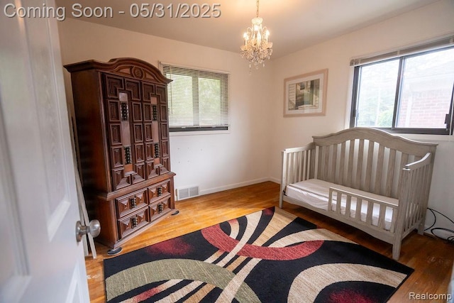 29974 Tamarack Dr, Flat Rock, MI 48134 - bedroom with wood finished floors, a chandelier, and baseboards