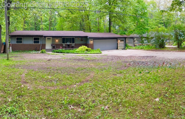 5844 Crandall Rd, Howell, MI 48855 - view of front of home featuring brick siding, a garage, concrete driveway, and a porch