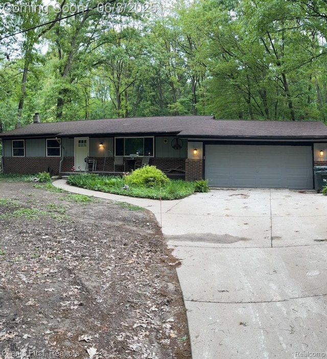 5844 Crandall Rd, Howell, MI 48855 - single story home featuring brick siding, an attached garage, concrete driveway, covered porch, and a shingled roof