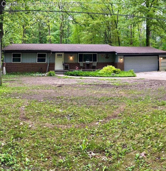 5844 Crandall Rd, Howell, MI 48855 - ranch-style home with brick siding, a garage, covered porch, and driveway