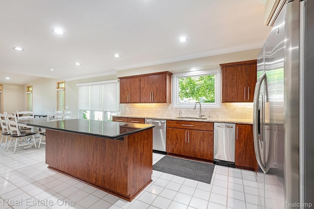 5299 Pond Bluff Dr, West Bloomfield, MI 48323 - kitchen with appliances with stainless steel finishes, a sink, decorative backsplash, crown molding, and light stone countertops