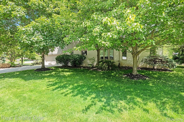 5299 Pond Bluff Dr, West Bloomfield, MI 48323 - view of green lawn featuring driveway