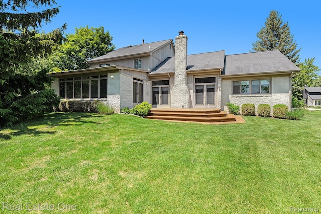 5299 Pond Bluff Dr, West Bloomfield, MI 48323 - rear view of house with brick siding, a chimney, and a lawn