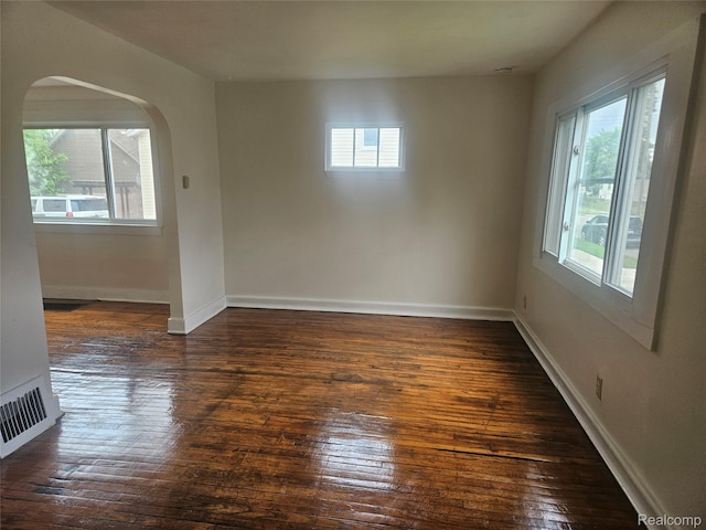 4634 8th St, Ecorse, MI 48229 - unfurnished room with arched walkways, dark wood-style flooring, and baseboards