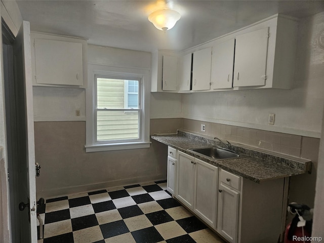 4634 8th St, Ecorse, MI 48229 - kitchen with a sink, light floors, backsplash, dark countertops, and white cabinets