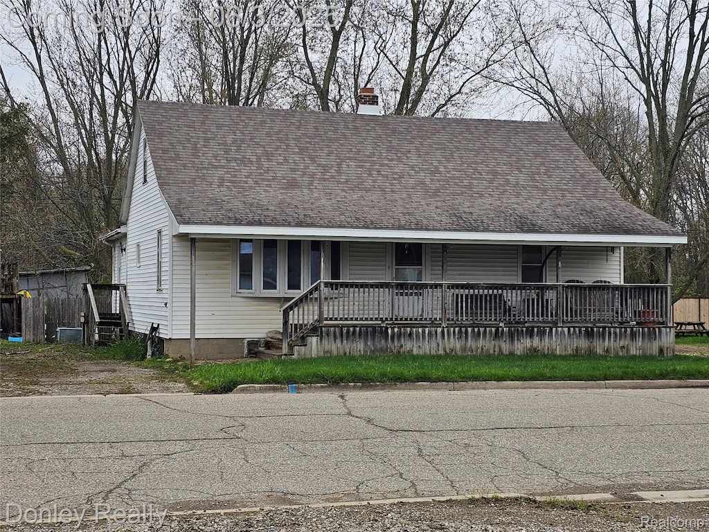 292 Lexington St, Sandusky, MI 48471 - view of front of house with covered porch, a chimney, and roof with shingles