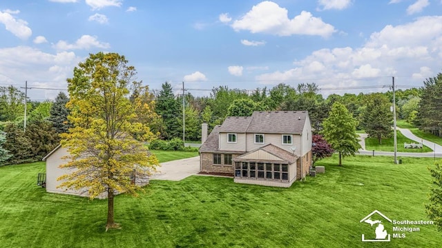 177 W Willis Rd, Saline, MI 48176 - rear view of property featuring a sunroom, a chimney, and a lawn