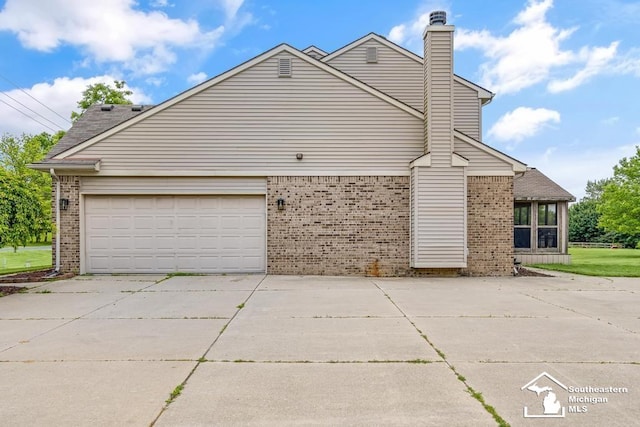 177 W Willis Rd, Saline, MI 48176 - view of property exterior featuring brick siding, concrete driveway, and a chimney