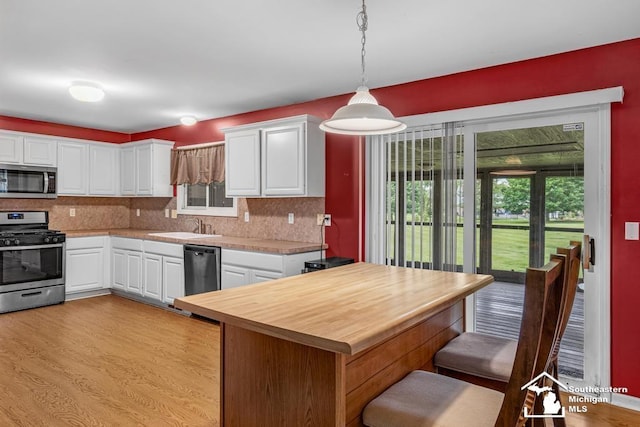 177 W Willis Rd, Saline, MI 48176 - kitchen with stainless steel appliances, backsplash, light wood-type flooring, and white cabinetry