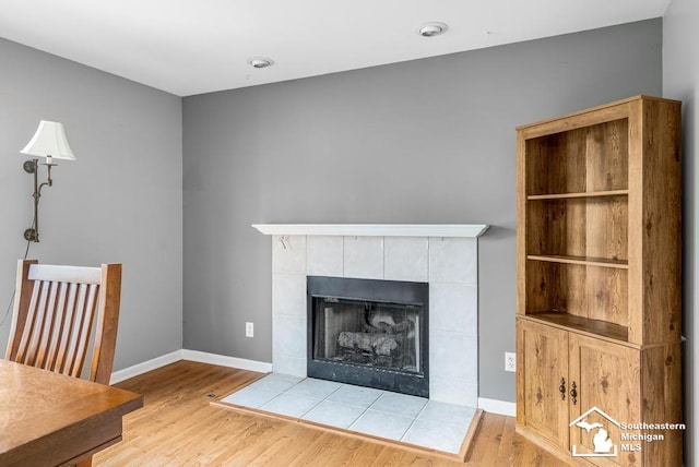 177 W Willis Rd, Saline, MI 48176 - unfurnished living room with wood finished floors, a tiled fireplace, and baseboards