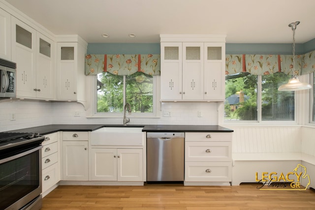 301 Sligh Blvd NE, Grand Rapids, MI 49505 - kitchen featuring appliances with stainless steel finishes, a sink, dark countertops, and tasteful backsplash