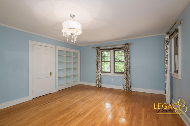 301 Sligh Blvd NE, Grand Rapids, MI 49505 - empty room with a chandelier, wood finished floors, ornamental molding, and baseboards