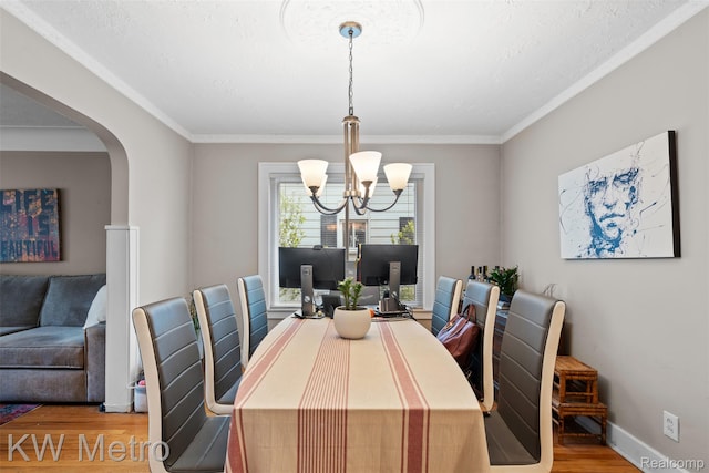 634 E Lewiston Ave, Ferndale, MI 48220 - dining area with a chandelier, wood finished floors, crown molding, arched walkways, and baseboards