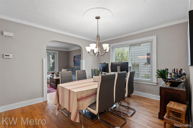 634 E Lewiston Ave, Ferndale, MI 48220 - dining area with arched walkways, a chandelier, plenty of natural light, baseboards, and crown molding