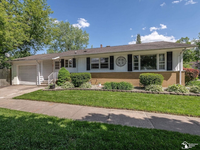 424 W 4th St, Monroe, MI 48161 - ranch-style house with brick siding, an attached garage, a front lawn, and concrete driveway
