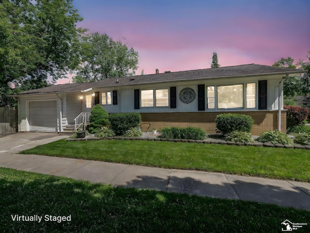 424 W 4th St, Monroe, MI 48161 - ranch-style home with brick siding, an attached garage, concrete driveway, and a lawn