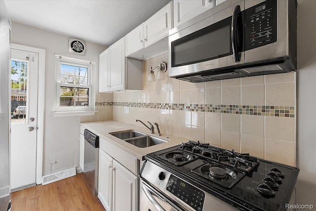 22865 Lakeshore Dr, Saint Clair Shores, MI 48080 - kitchen featuring appliances with stainless steel finishes, a sink, white cabinetry, and backsplash