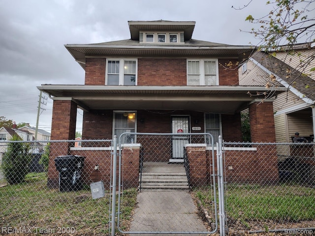 1601 Lawndale St, Highland Park, MI 48209 - american foursquare style home featuring covered porch, a gate, brick siding, and a fenced front yard
