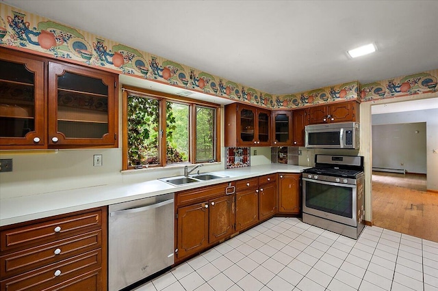 2100 Delhi W, Ann Arbor, MI 48103 - kitchen featuring stainless steel appliances, a sink, a baseboard radiator, light countertops, and glass insert cabinets