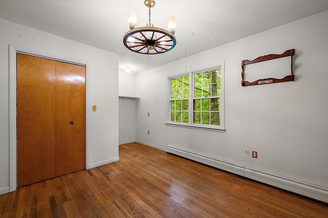 2100 Delhi W, Ann Arbor, MI 48103 - unfurnished bedroom with baseboard heating, wood-type flooring, a chandelier, and baseboards