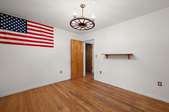 2100 Delhi W, Ann Arbor, MI 48103 - unfurnished room with baseboards, a chandelier, and wood finished floors