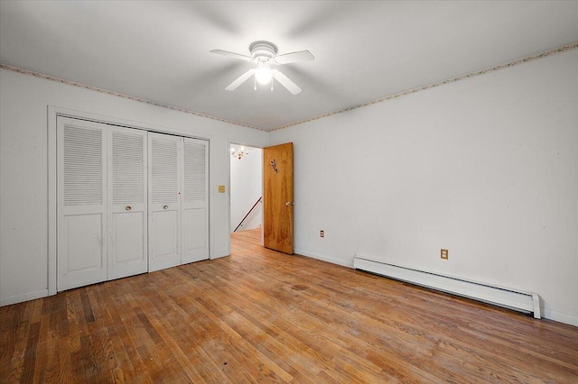 2100 Delhi W, Ann Arbor, MI 48103 - unfurnished bedroom with a baseboard radiator, wood finished floors, a closet, ceiling fan, and baseboards