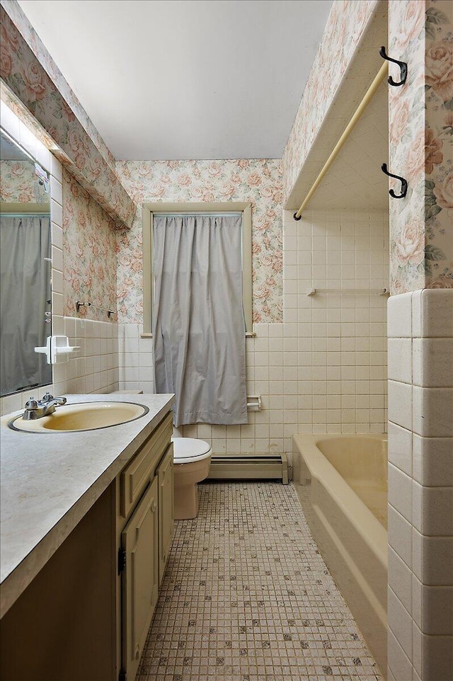 2100 Delhi W, Ann Arbor, MI 48103 - bathroom featuring wallpapered walls, tile walls, a baseboard heating unit, toilet, and wainscoting
