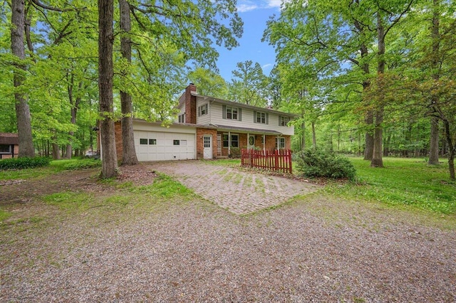 2100 Delhi W, Ann Arbor, MI 48103 - view of front of house featuring a chimney, brick siding, driveway, covered porch, and an attached garage