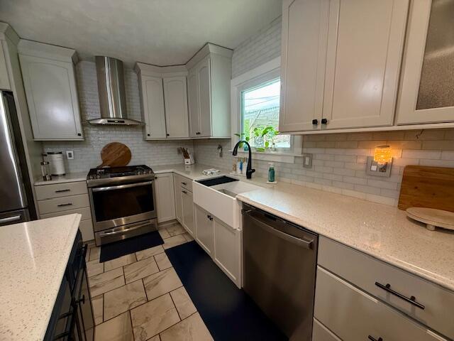 307 W 30th St, Holland, MI 49423 - kitchen featuring stainless steel appliances, wall chimney exhaust hood, a sink, light marble finish floors, and tasteful backsplash