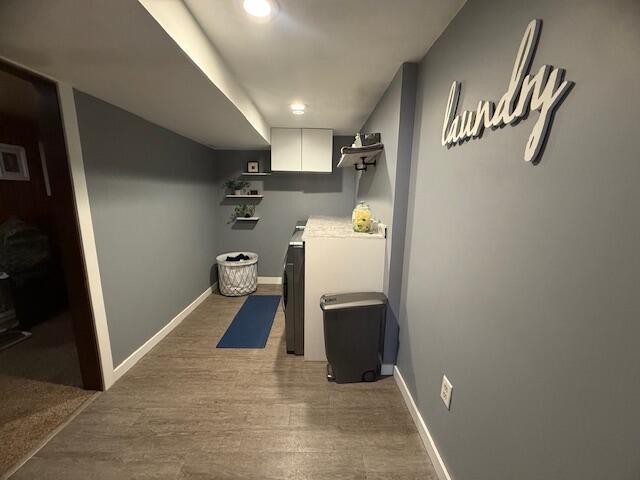 307 W 30th St, Holland, MI 49423 - washroom featuring washer and clothes dryer, baseboards, light wood-type flooring, and cabinet space