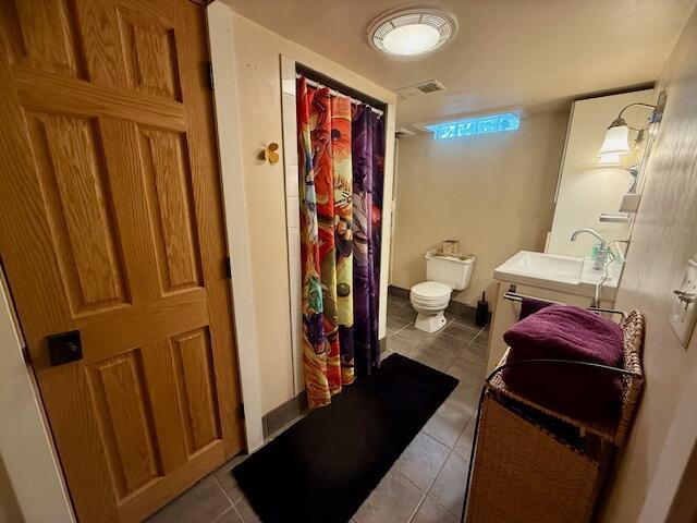 307 W 30th St, Holland, MI 49423 - full bathroom featuring tile patterned flooring, toilet, vanity, and a shower with shower curtain