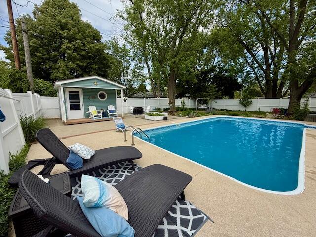 307 W 30th St, Holland, MI 49423 - view of pool featuring a patio, a fenced backyard, a storage structure, and an outdoor structure
