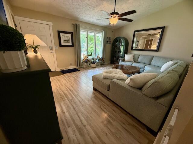 307 W 30th St, Holland, MI 49423 - living room with wood finished floors, a textured ceiling, a ceiling fan, and vaulted ceiling