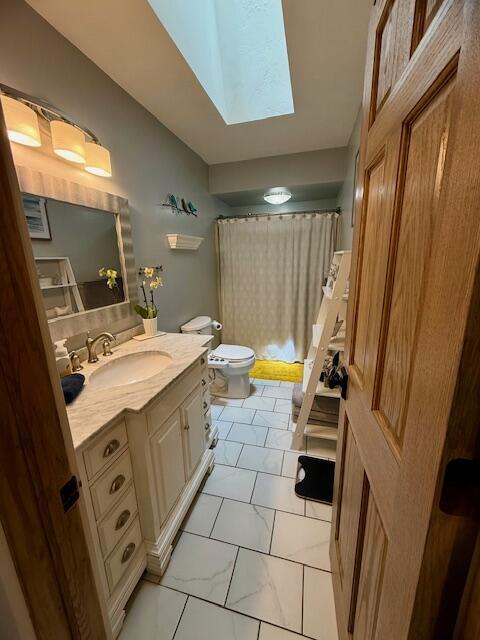 307 W 30th St, Holland, MI 49423 - bathroom featuring toilet, vanity, a skylight, a shower with curtain, and marble finish flooring