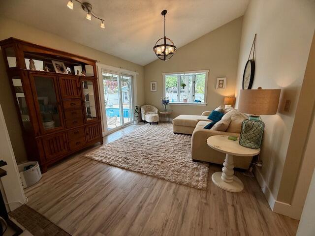 307 W 30th St, Holland, MI 49423 - living room with wood finished floors, lofted ceiling, a chandelier, and baseboards