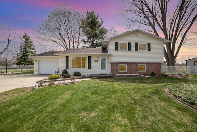 2615 Yosemite St, Saginaw, MI 48603 - tri-level home with driveway, brick siding, and an attached garage